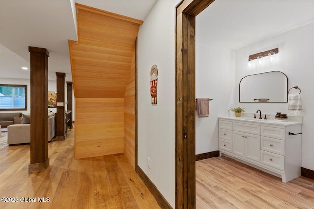 1181 Hunt Lake Rd Unit N, Corinth, NY 12822 - corridor with light wood-type flooring, decorative columns, baseboards, and a sink