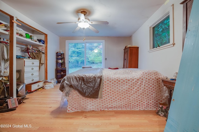 bedroom with ceiling fan, access to outside, and wood finished floors