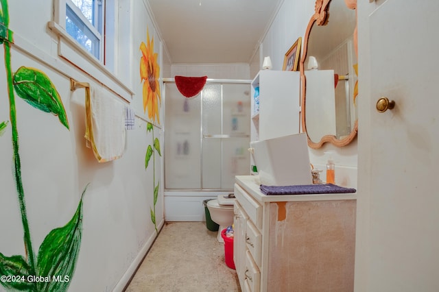 full bath with toilet, crown molding, combined bath / shower with glass door, vanity, and baseboards