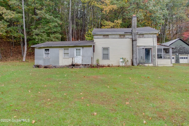 view of front of property with a front lawn, a sunroom, and a chimney