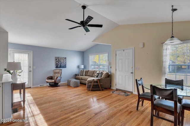 living room featuring light wood-style floors, a ceiling fan, lofted ceiling, and a wealth of natural light