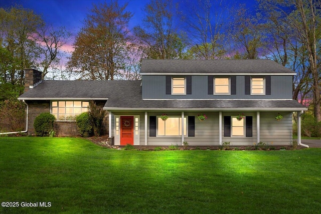 view of front of home with a front yard, a chimney, and a porch