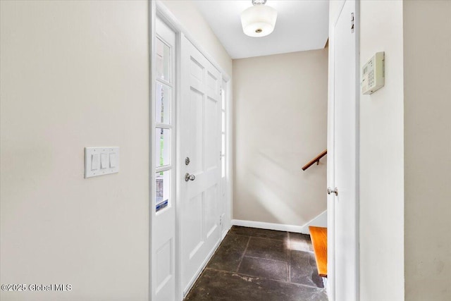 foyer with stone tile flooring and baseboards