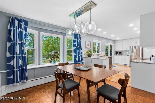 dining space featuring a baseboard radiator and recessed lighting
