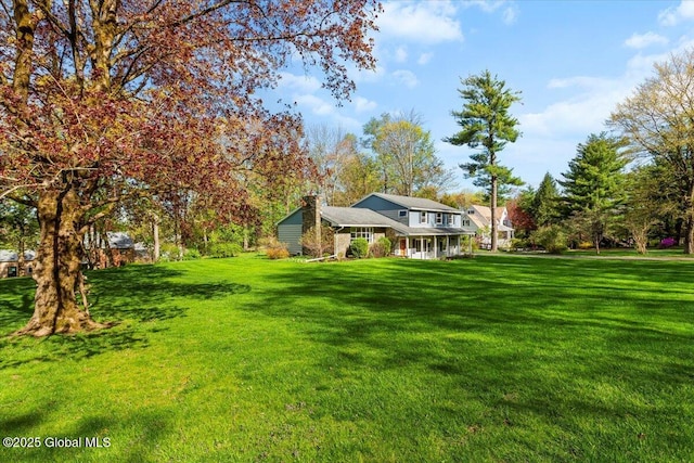view of grassy yard with covered porch