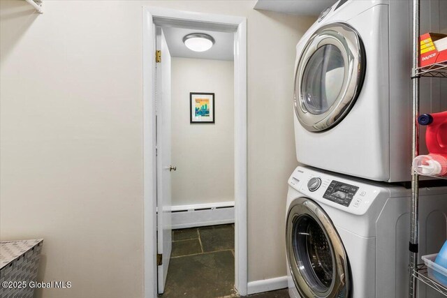 clothes washing area with stacked washer / dryer and baseboard heating