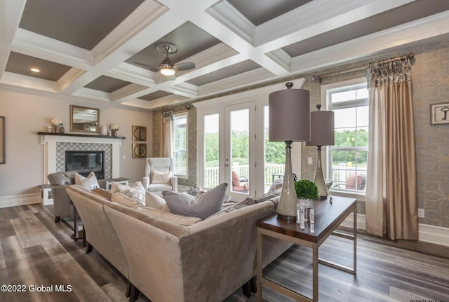 living room with dark wood finished floors, a tile fireplace, and baseboards
