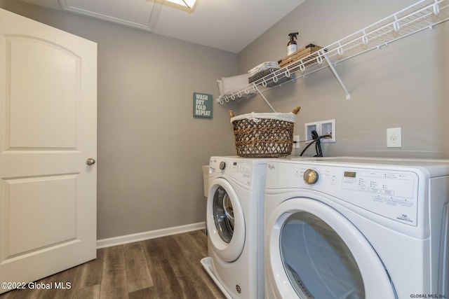 washroom with baseboards, separate washer and dryer, dark wood-style flooring, and laundry area