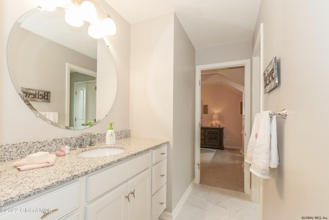 bathroom with baseboards, marble finish floor, and vanity