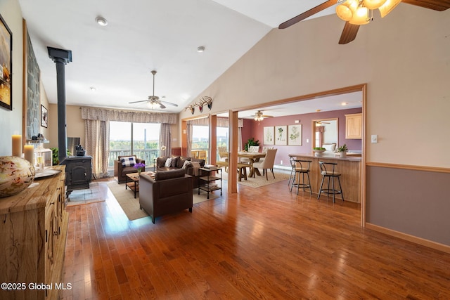 2694 State Route 10, Summit, NY 12175 - living area with a ceiling fan, a wood stove, wood finished floors, high vaulted ceiling, and baseboards