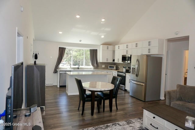 kitchen featuring tasteful backsplash, white cabinetry, a center island, and stainless steel appliances