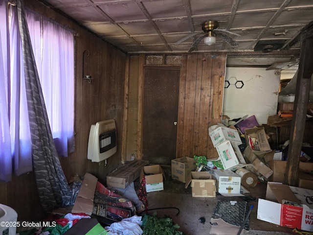 miscellaneous room with a ceiling fan, heating unit, and wooden walls