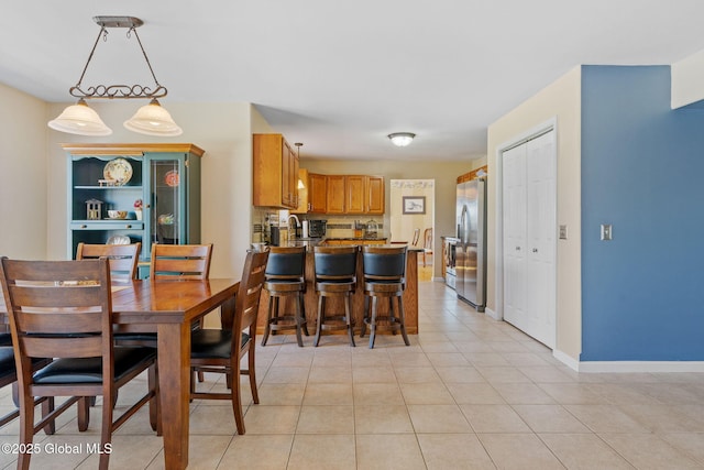 dining space with baseboards and light tile patterned floors