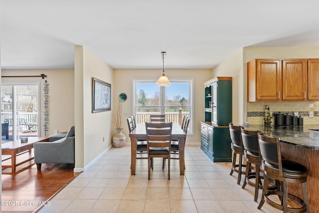 dining room with light tile patterned flooring and baseboards