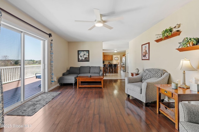 living area with a ceiling fan and dark wood finished floors