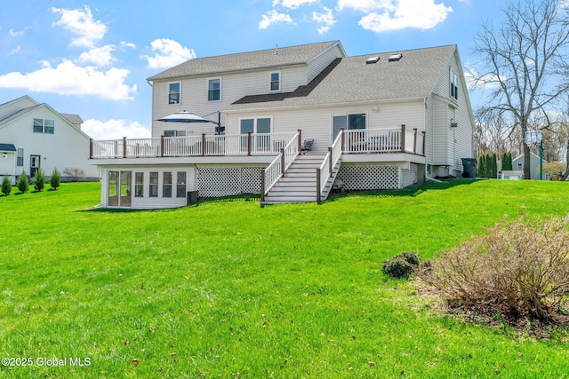 back of house with a lawn, a wooden deck, and a shingled roof