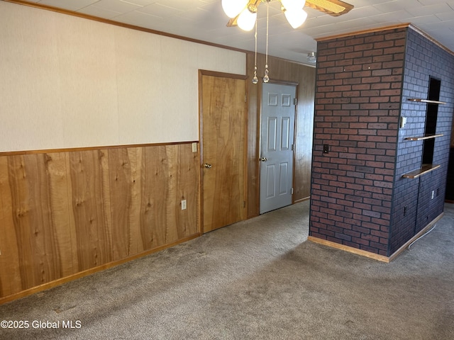 6 Riverview St, South Glens Falls, NY 12803 - carpeted empty room with ornamental molding, brick wall, wood walls, and ceiling fan