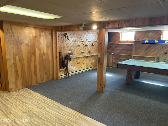 6 Riverview St, South Glens Falls, NY 12803 - playroom with a baseboard heating unit, wood walls, carpet flooring, and a drop ceiling