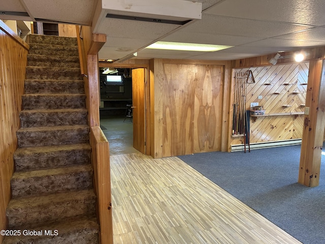 6 Riverview St, South Glens Falls, NY 12803 - finished below grade area with baseboard heating, stairs, a drop ceiling, carpet, and wood walls