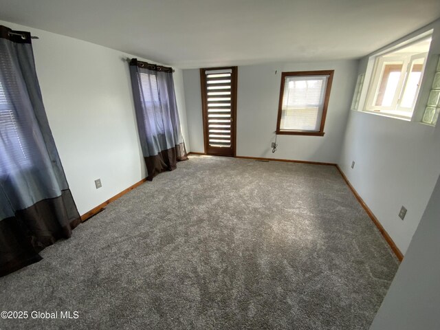 unfurnished room featuring baseboards and carpet flooring