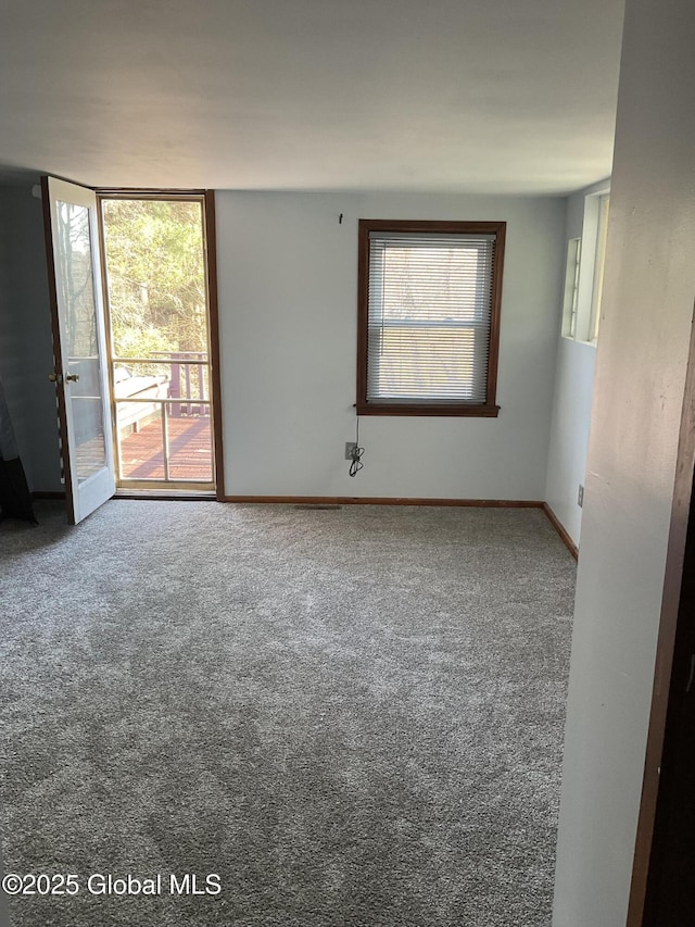 empty room featuring carpet and baseboards