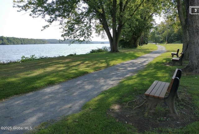view of home's community with a lawn and a water view