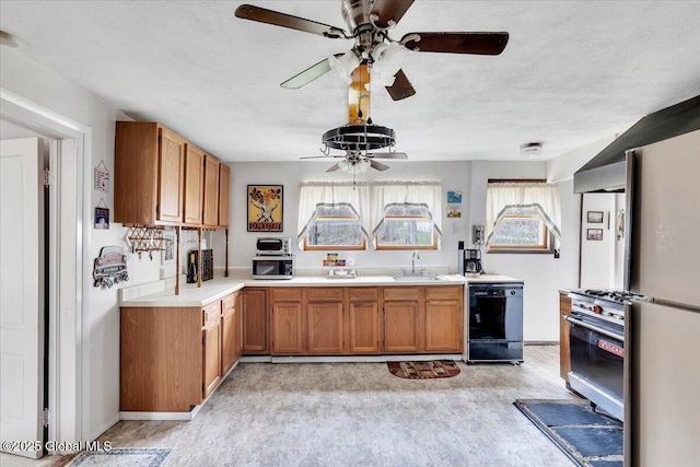 kitchen with a ceiling fan, brown cabinets, a sink, dishwasher, and gas stove