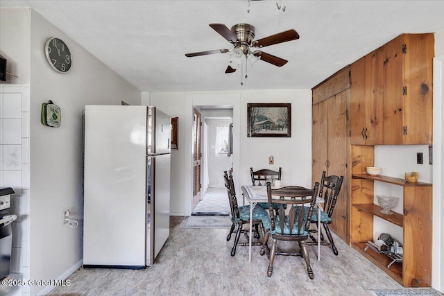 dining space with baseboards and a ceiling fan