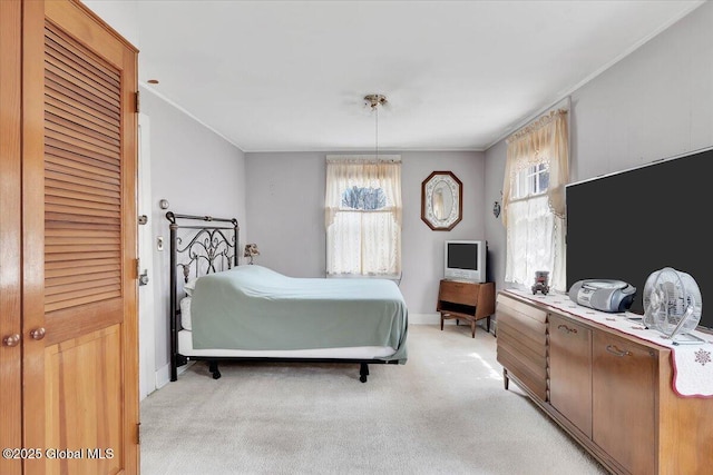 bedroom with crown molding, baseboards, and light carpet
