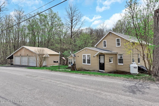view of front of property with a garage and an outbuilding