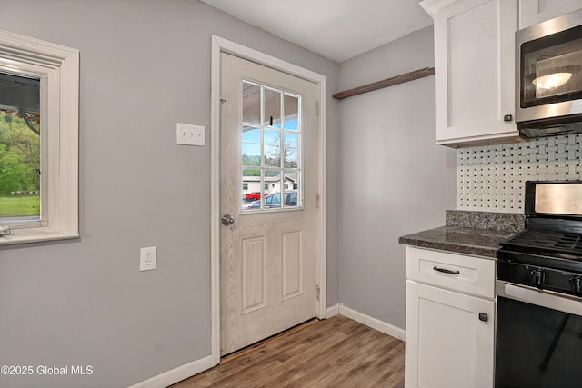 286 State Hwy Unit 80, Fort Plain, NY 13339 - kitchen featuring stainless steel microwave, gas range, baseboards, white cabinetry, and light wood-style floors