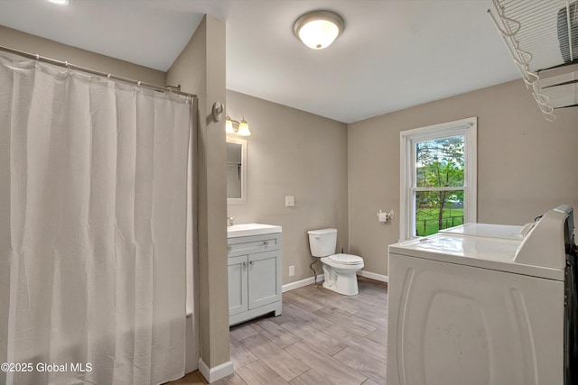286 State Hwy Unit 80, Fort Plain, NY 13339 - bathroom featuring washing machine and dryer, vanity, toilet, baseboards, and wood finished floors