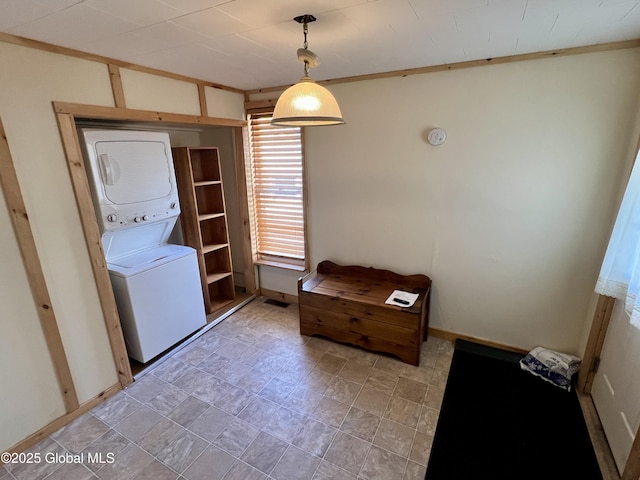 washroom featuring stacked washer / drying machine and laundry area