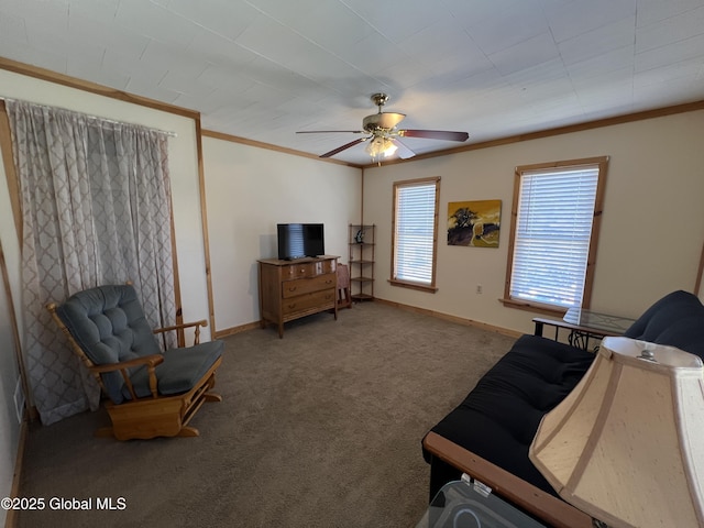 carpeted living room with baseboards, a ceiling fan, and crown molding