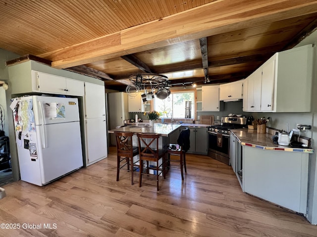 kitchen with stainless steel range with gas cooktop, wood ceiling, light wood-style flooring, beam ceiling, and freestanding refrigerator