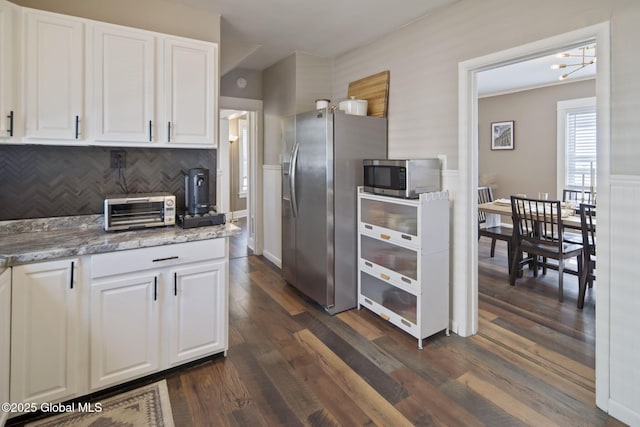 kitchen with white cabinets, appliances with stainless steel finishes, decorative backsplash, and a toaster
