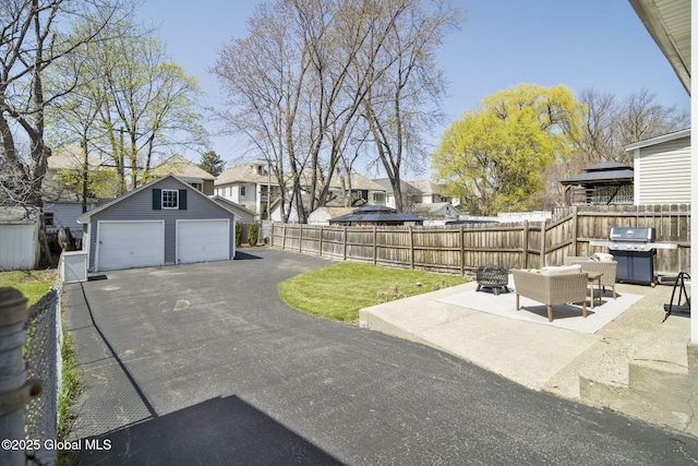exterior space featuring fence, a detached garage, an outbuilding, and a residential view