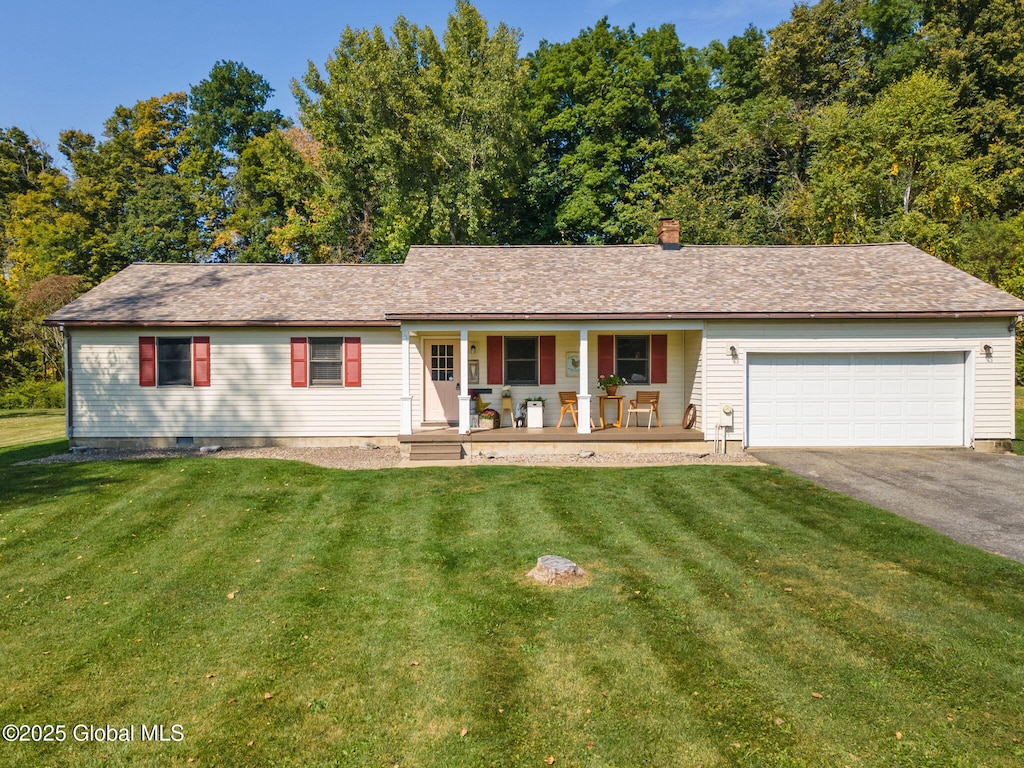 ranch-style home featuring a chimney, a front lawn, an attached garage, driveway, and a porch