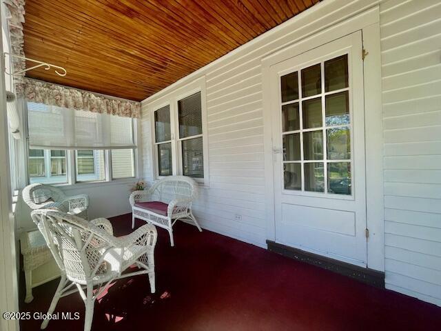 exterior space featuring wood ceiling and wood walls