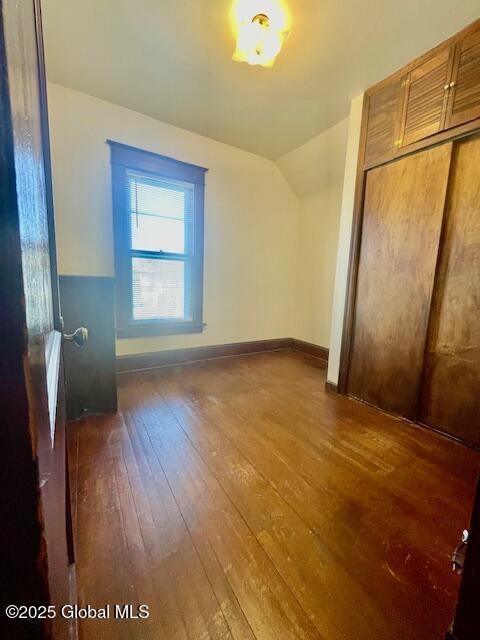 bonus room with baseboards, wood-type flooring, and vaulted ceiling