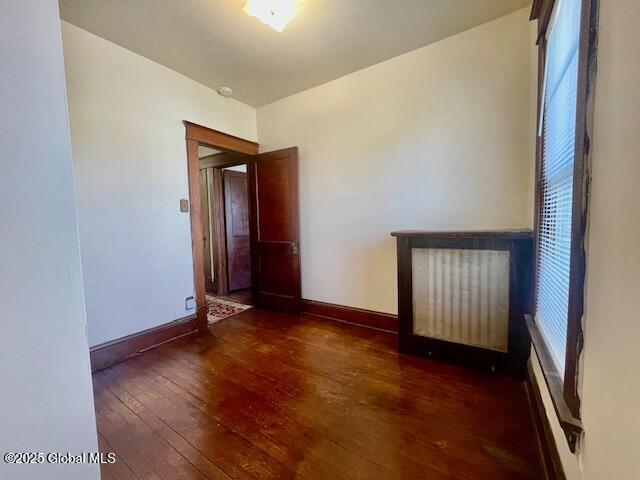 unfurnished room featuring baseboards and hardwood / wood-style flooring