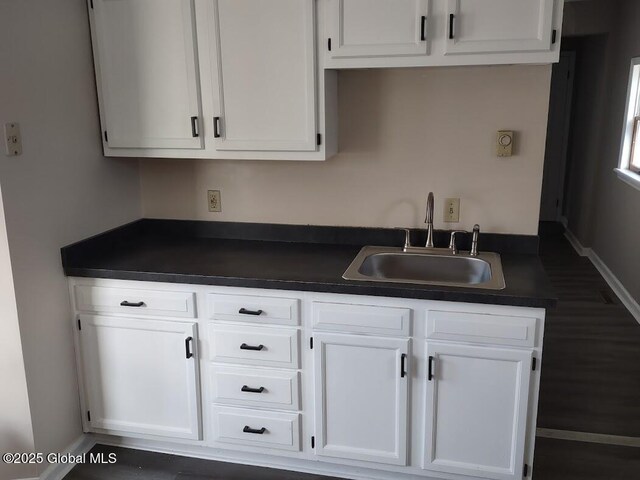 178 Spring St, Albany, NY 12203 - kitchen with a sink, dark countertops, and white cabinetry