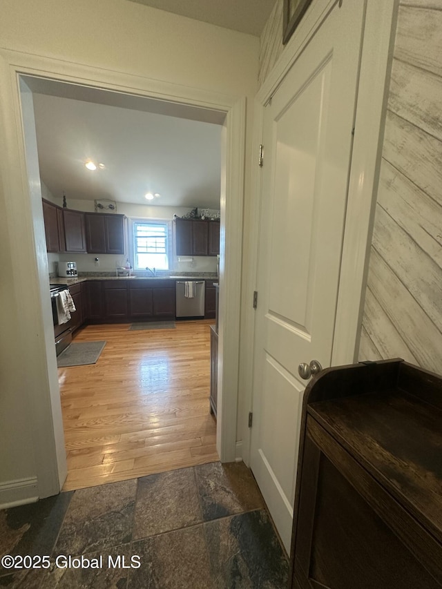 kitchen with light wood finished floors, appliances with stainless steel finishes, and dark brown cabinets