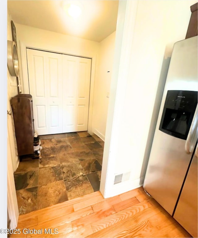 hall with baseboards and stone finish floor