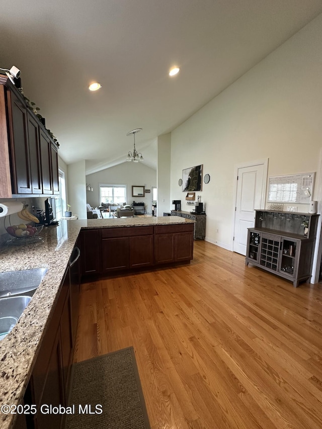 37 Nantucket St, Colonie, NY 12047 - kitchen featuring dark brown cabinetry, light wood-style floors, open floor plan, recessed lighting, and high vaulted ceiling