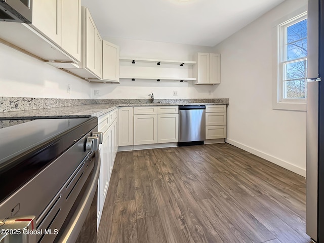 kitchen with open shelves, appliances with stainless steel finishes, dark wood-style floors, and light stone counters