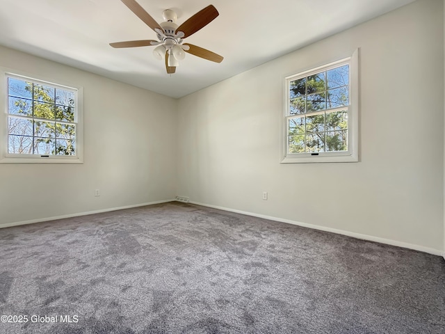 unfurnished room with a ceiling fan, baseboards, and carpet