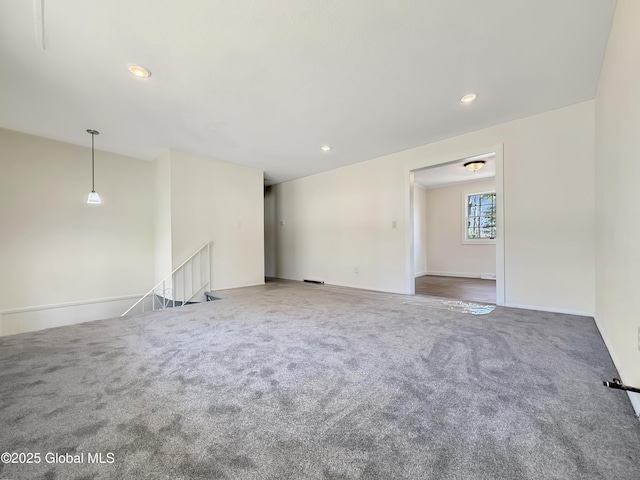 unfurnished living room with recessed lighting, baseboards, and carpet