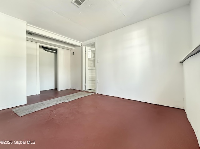 unfurnished bedroom with visible vents, concrete floors, and a closet