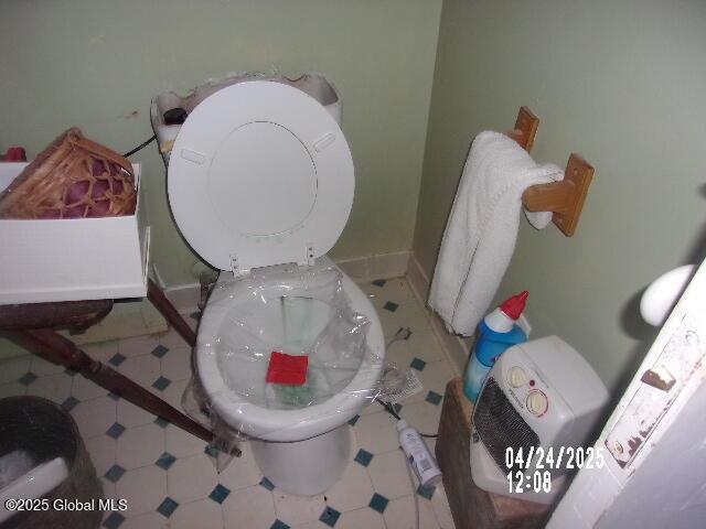 bathroom with toilet, tile patterned floors, and baseboards